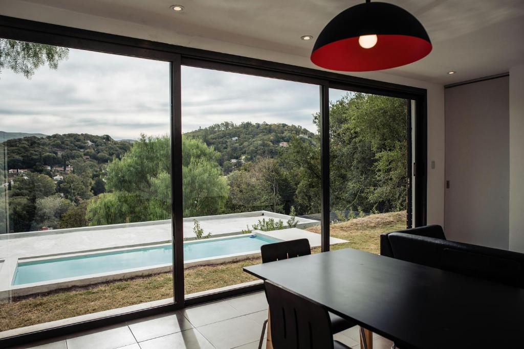 een eetkamer met uitzicht op een zwembad door een groot raam bij Vistasol in Río Ceballos