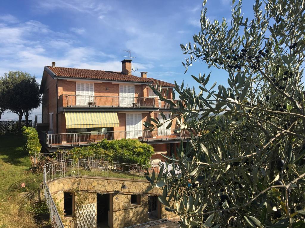 una casa con balcone e albero di Casa La Mignola a San Miniato