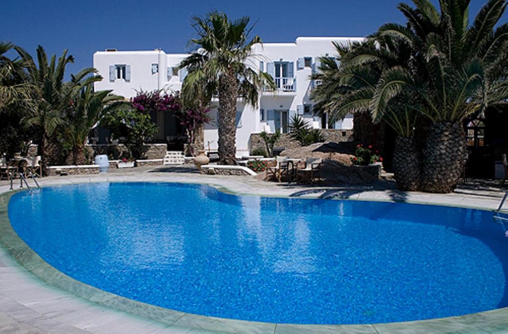 a large blue swimming pool in front of a white house at Zephyros in Paraga