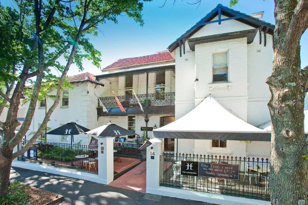 - un bâtiment blanc avec des parasols en face dans l'établissement The Hughenden Boutique Hotel, à Sydney