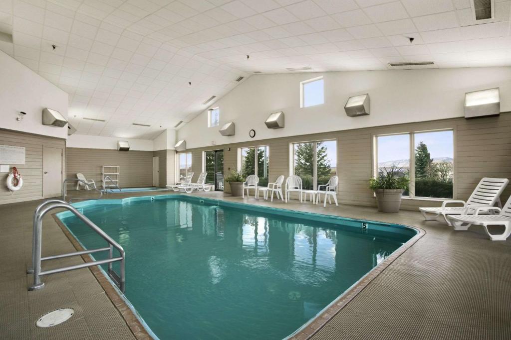 una gran piscina en un edificio con sillas en Days Inn by Wyndham Rapid City, en Rapid City
