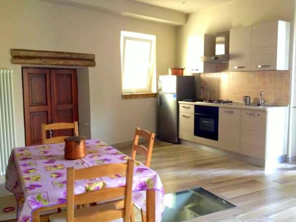 a kitchen with a table and chairs and a kitchen with a table and a table at La Giazzera in Dervio