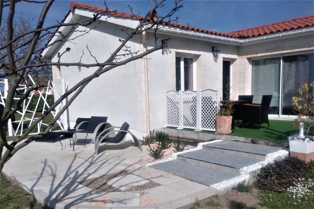 uma casa branca com um alpendre e escadas em Le Soleil en Gironde em Vrillant