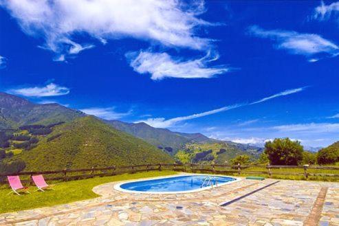 a patio with two chairs and a swimming pool at Apartamentos El Patio in Lerones