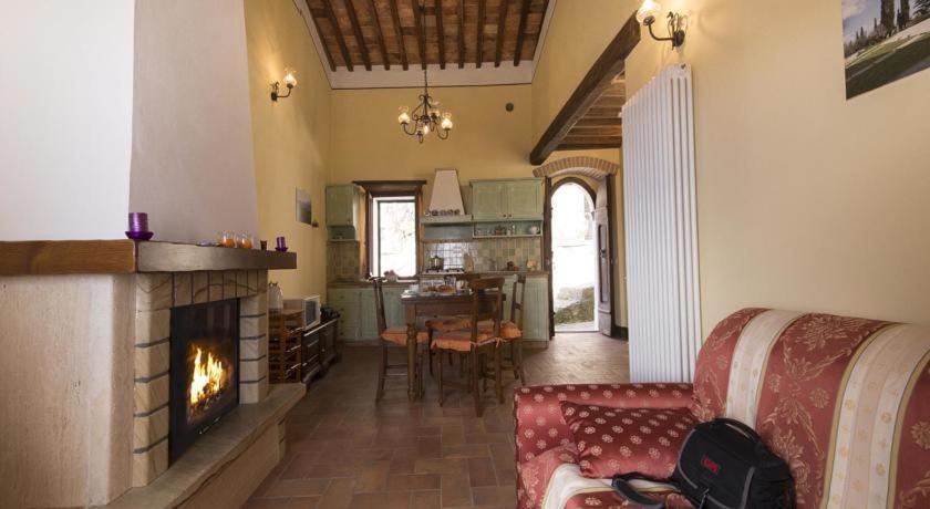 a living room with a couch and a fireplace at Casa Bandino in Campiglia dʼOrcia