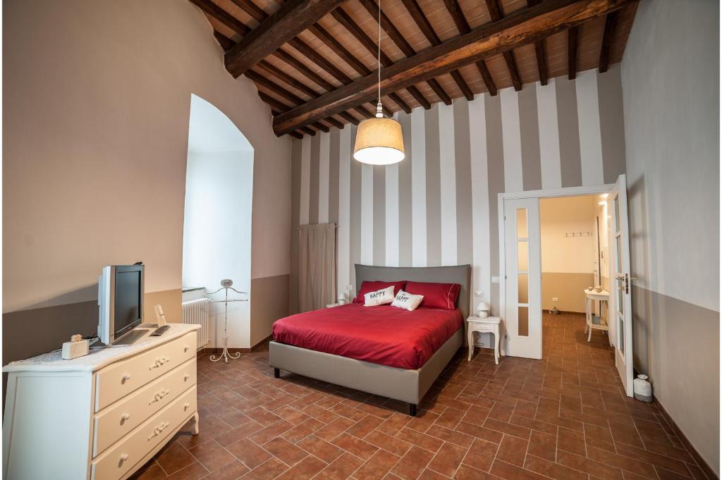 a bedroom with a red bed and a television at La dimora nel Castello in Collevalenza
