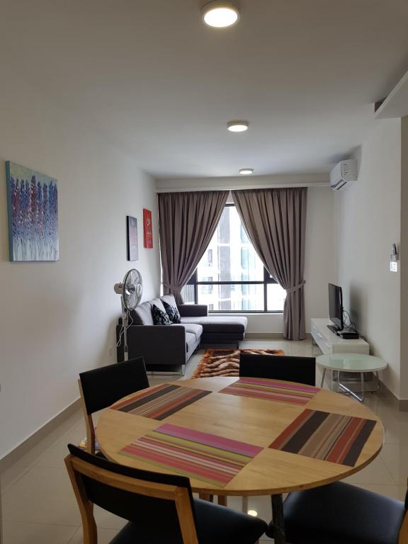 a living room with a table and a couch at Eclipse Residence Pangea in Cyberjaya