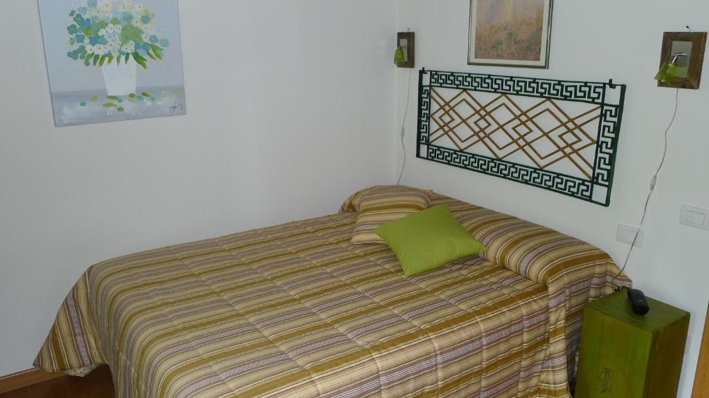 um quarto com uma cama com uma almofada verde em La Casa di Campagna em Spresiano