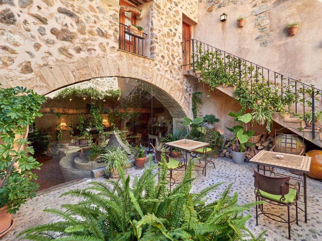 a garden area with a patio and a balcony at Hotel Nord in Estellencs