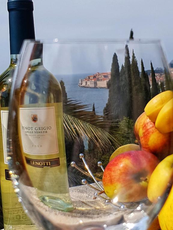 a bottle of wine sitting next to a bowl of apples at SoLeo in Dubrovnik