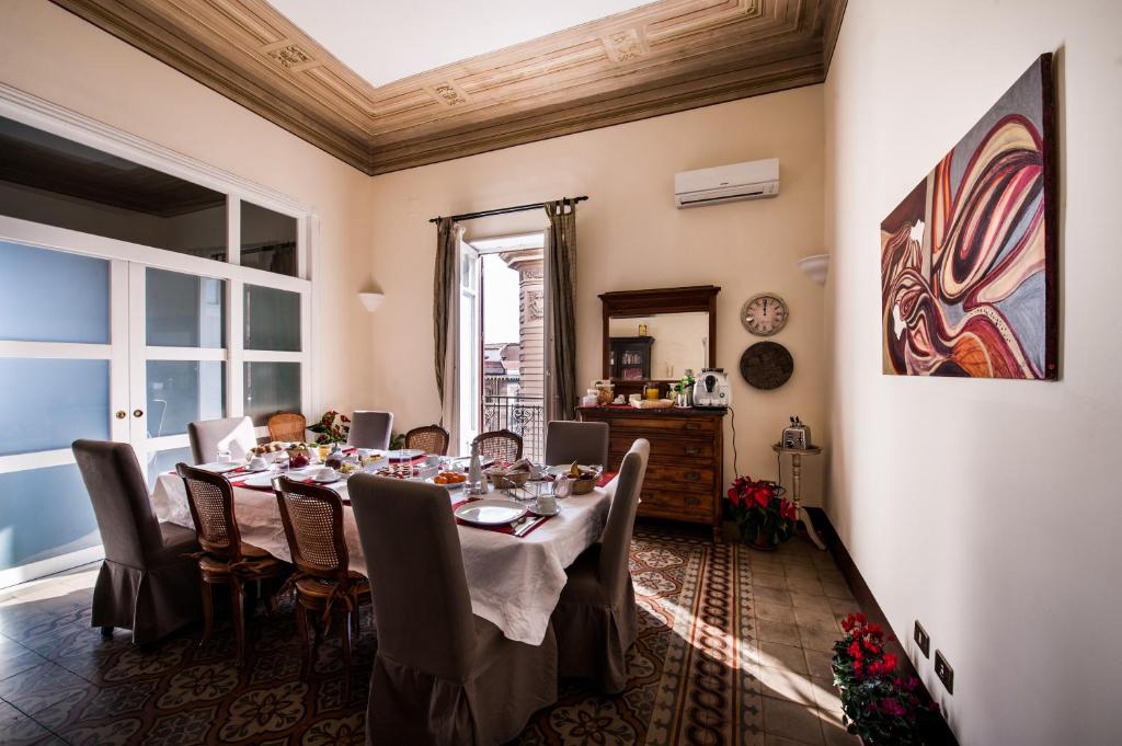 B&B Novecento في باليرمو: غرفة طعام مع طاولة وكراسي طويلة