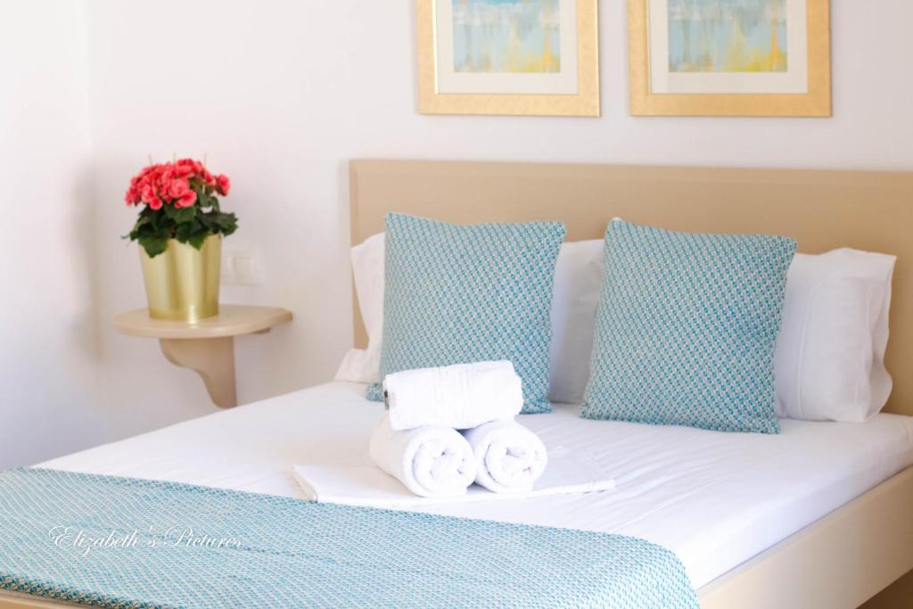 1 cama con almohadas y toallas azules y blancas en River Side Hotel, en Georgioupolis