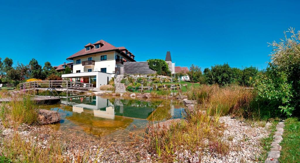 ein Haus mit einem Teich davor in der Unterkunft Hotel Weiss S in Neustift im Mühlkreis