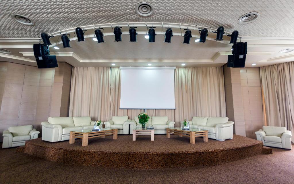 トズールにあるEl Mouradi Tozeurのソファとプロジェクションスクリーン付きの広い客室です。