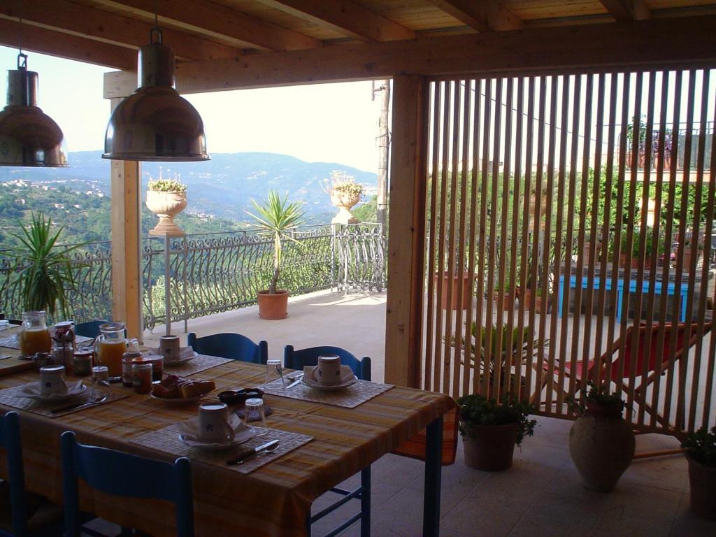 B&B Calabria في Scigliano: طاولة وكراسي خشبية على فناء مع اطلالة