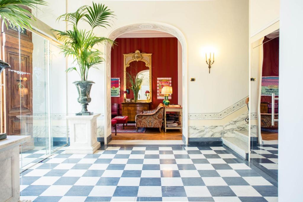 un corridoio con pavimento a scacchi in bianco e nero di Hotel Palazzo Guiscardo a Pietrasanta