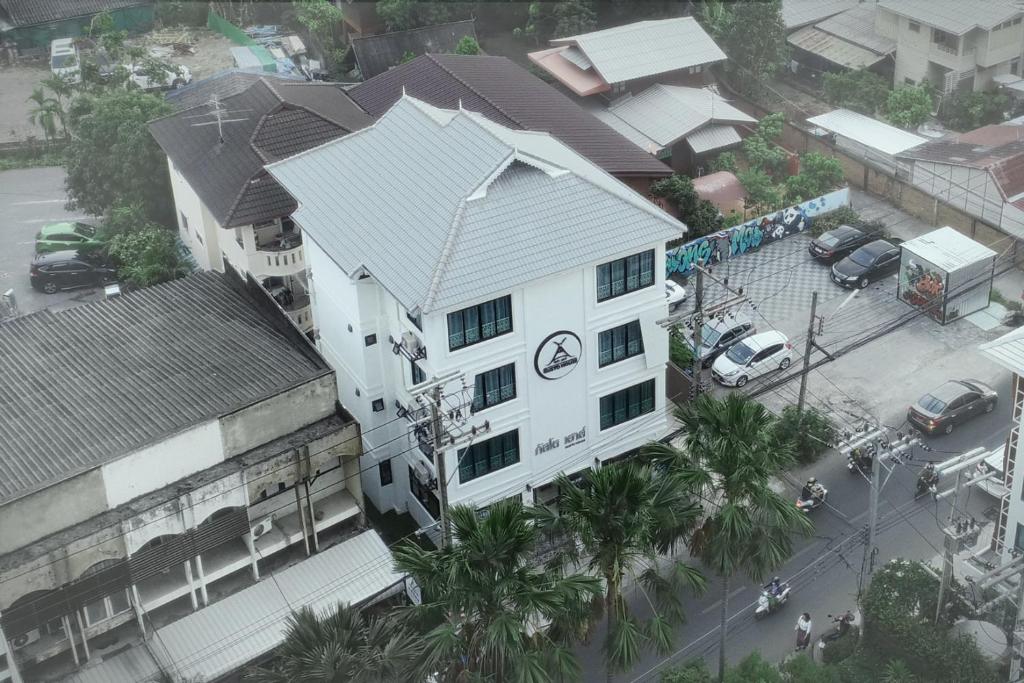 an overhead view of a white building with palm trees at Gusto House in Chiang Mai