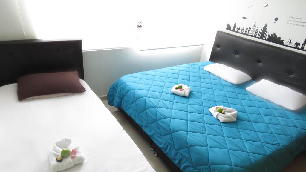 1 dormitorio con 2 camas con sábanas azules y almohadas blancas en Hotel Bogota House, en Bogotá