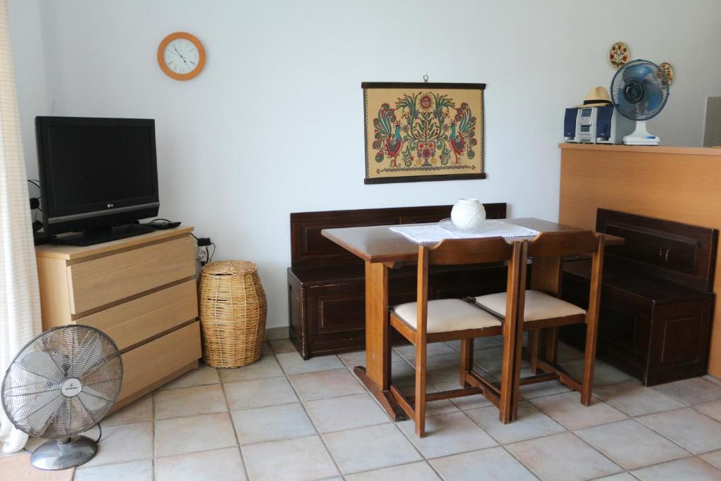 a room with a table and a tv and a table and chairs at Holiday Home by the Sea in Nea Potidaea