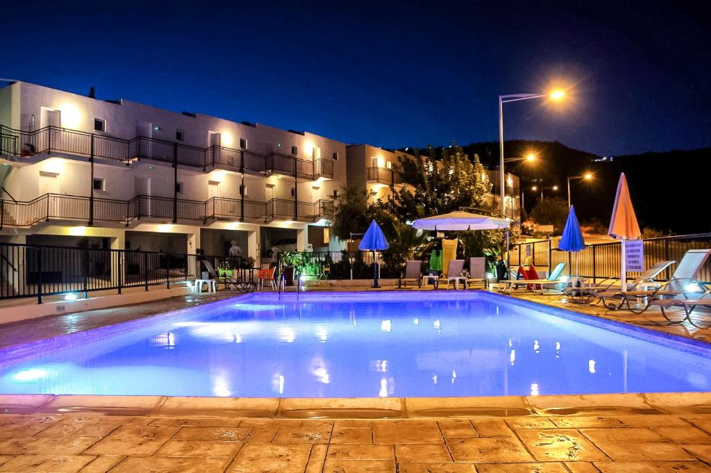 a large swimming pool in front of a building at night at Peyia Pearl in Peyia