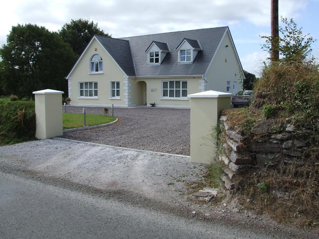 una casa blanca con una entrada delante de ella en Forgefield House en Kenmare