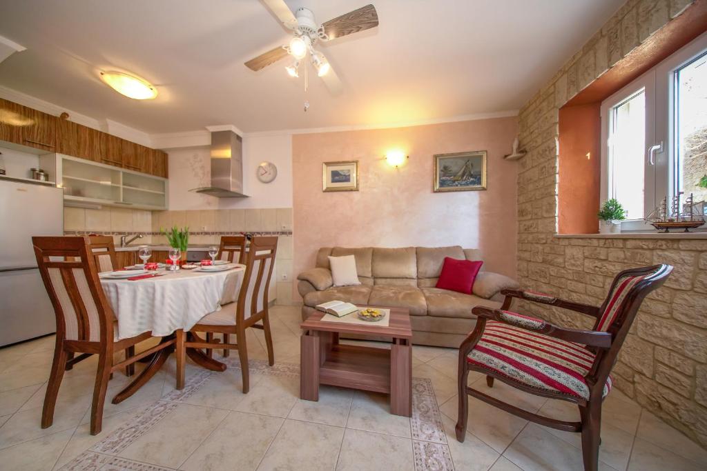 eine Küche und ein Wohnzimmer mit einem Tisch und einem Sofa in der Unterkunft Apartment Stara kuća in Mali Ston