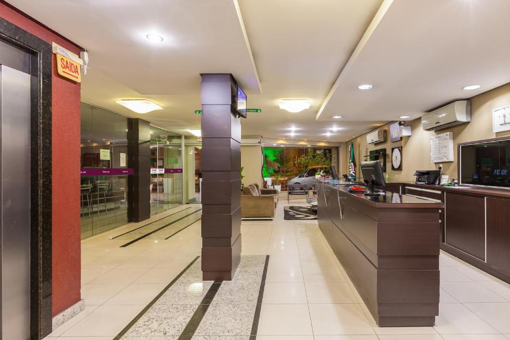 a lobby of a hotel with a reception desk at Rede Andrade Royal Criciúma in Criciúma
