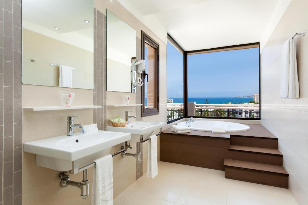 a bathroom with two sinks and a large window at Tigotan Lovers & Friends Playa de las Americas - Adults Only (+18) in Playa de las Americas
