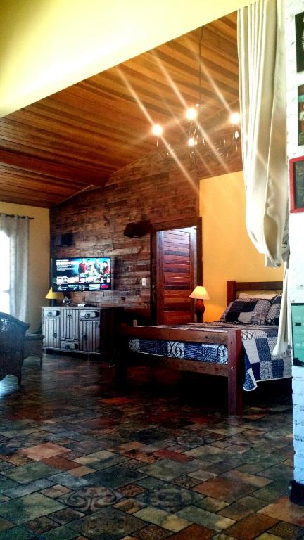 a bedroom with a bed and a tv in a room at Hospedagem Caminho do Lago in Cunha