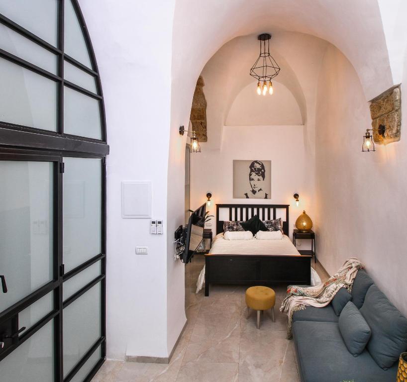 a bedroom with a bed and a couch at Acre Two Wells Zimmer in ‘Akko