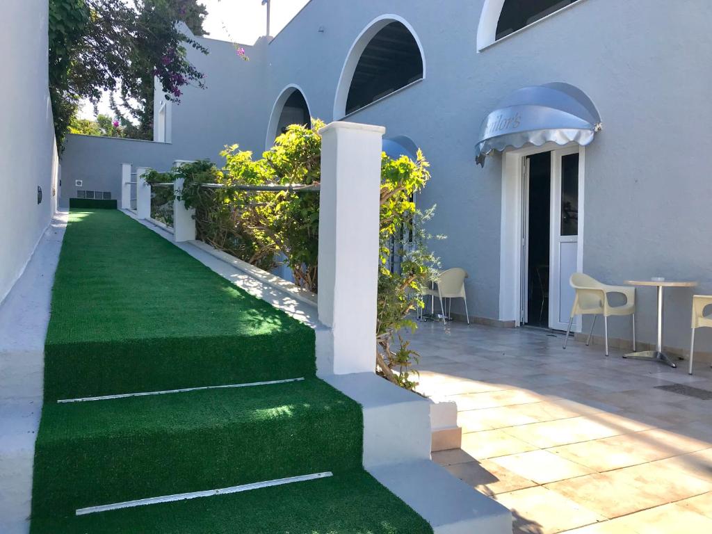 Biały dom z zielonym trawnikiem w obiekcie Sailor's Nautical Concept w mieście Spetses