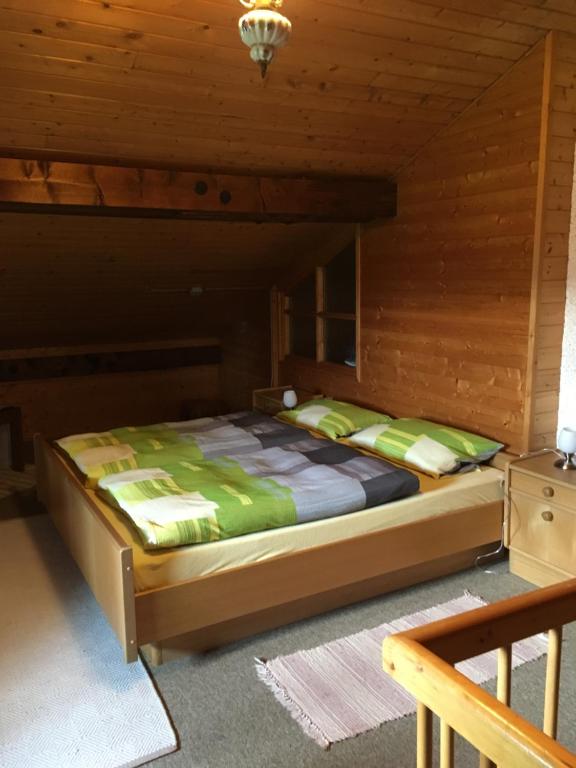 1 dormitorio con 1 cama en una cabaña de madera en Ferienhaus Charme en Regen