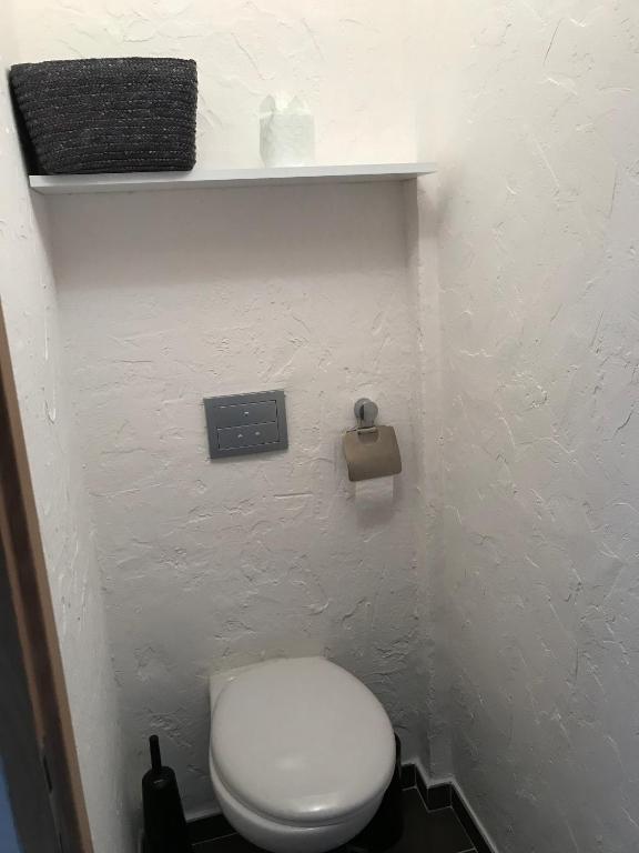 a bathroom with a white toilet and a white wall at Residence port la galere in Théoule-sur-Mer