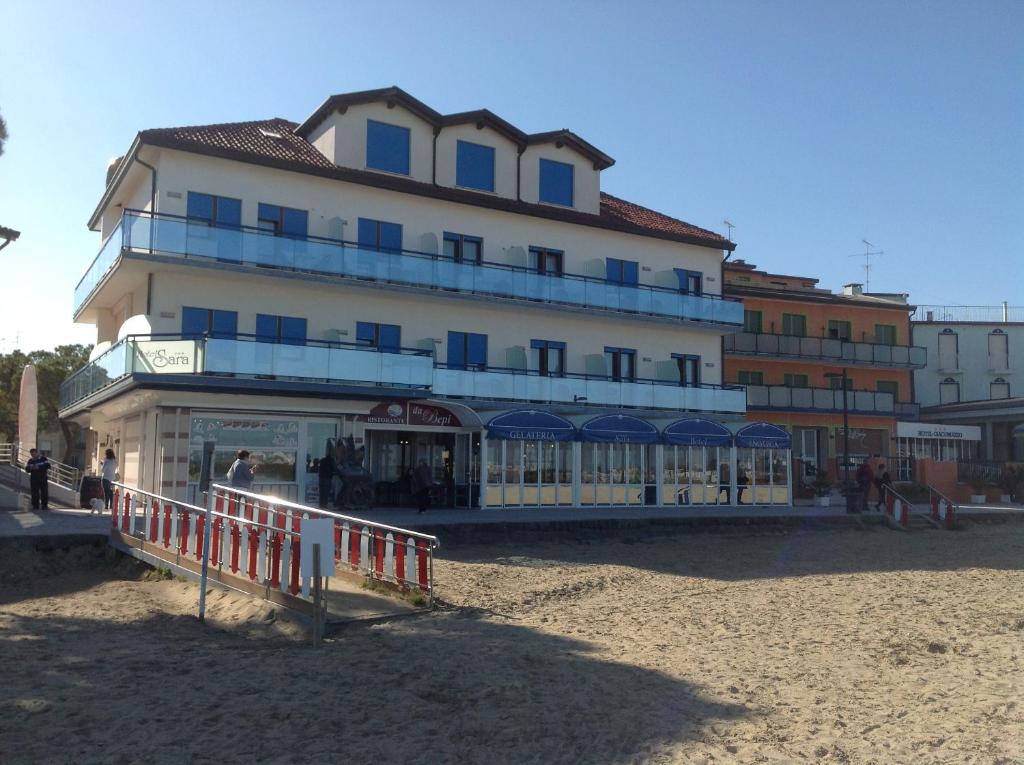 a large building on the beach in front of a building at Hotel Sara in Caorle