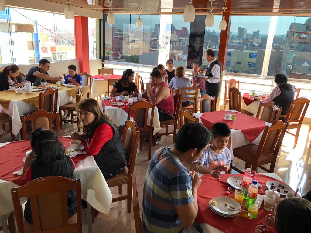 a group of people sitting at tables in a restaurant at Sumaq Hotel Tacna in Tacna