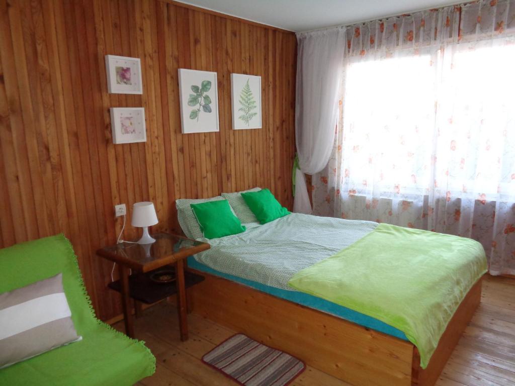 een slaapkamer met een bed, een stoel en een raam bij Uroczy Domek Z Ogrodem I Tarasem in Myślenice