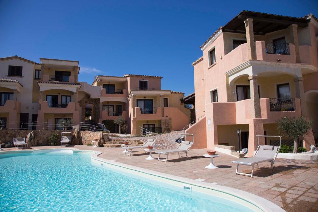 a villa with a swimming pool in front of a building at Bados Mare in Olbia