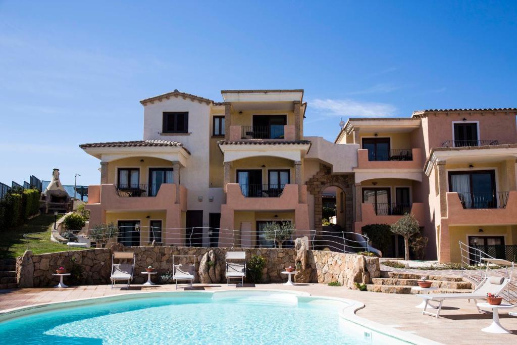 a large house with a swimming pool in front of it at Bados Mare in Olbia