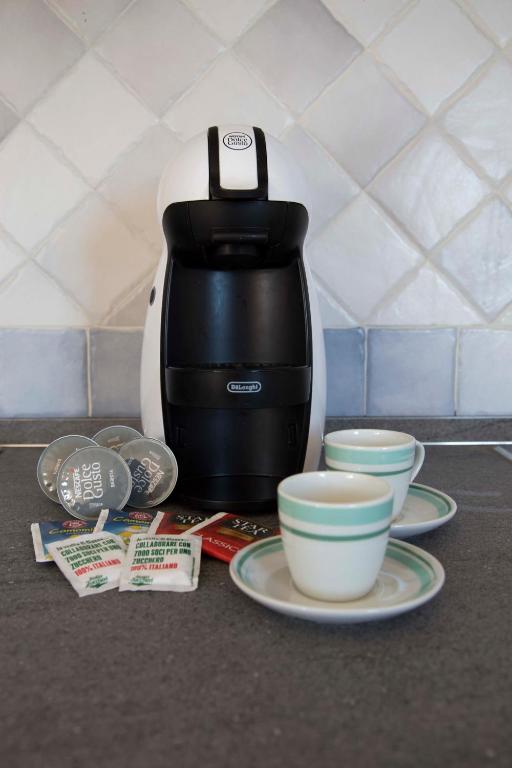 a coffee maker with plates and cups on a counter at Bados Mare in Olbia