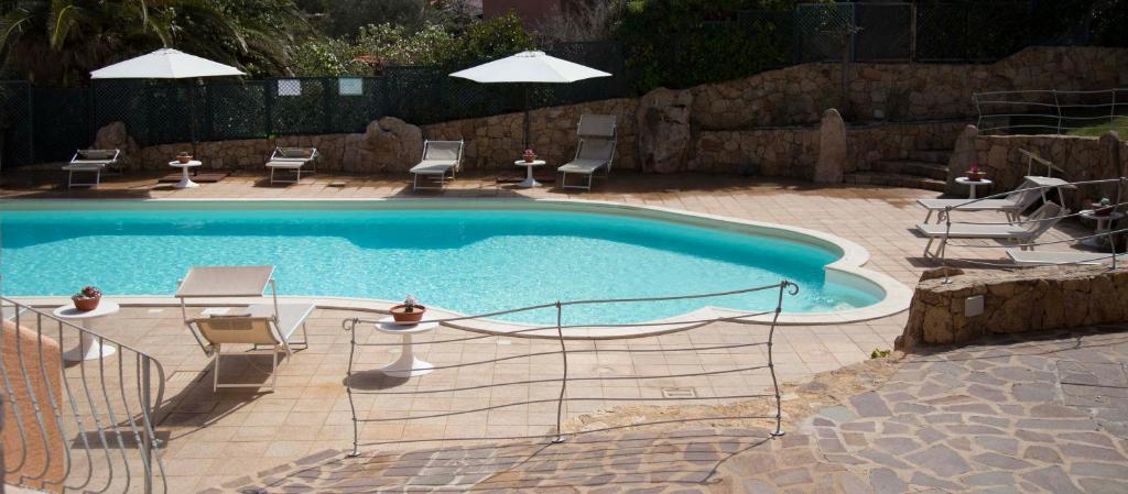 a swimming pool with chairs and a table and chairs at Bados Mare in Olbia