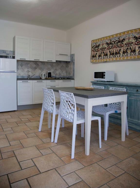 a kitchen with a table and chairs and a refrigerator at Bados Mare in Olbia