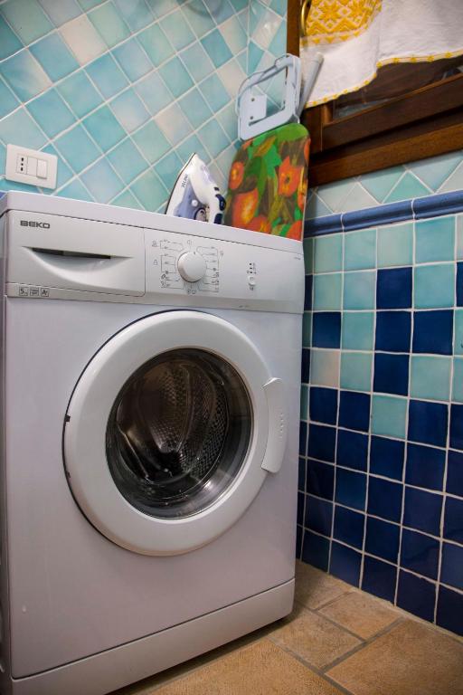 a washing machine in a kitchen with a blue tiled wall at Bados Mare in Olbia