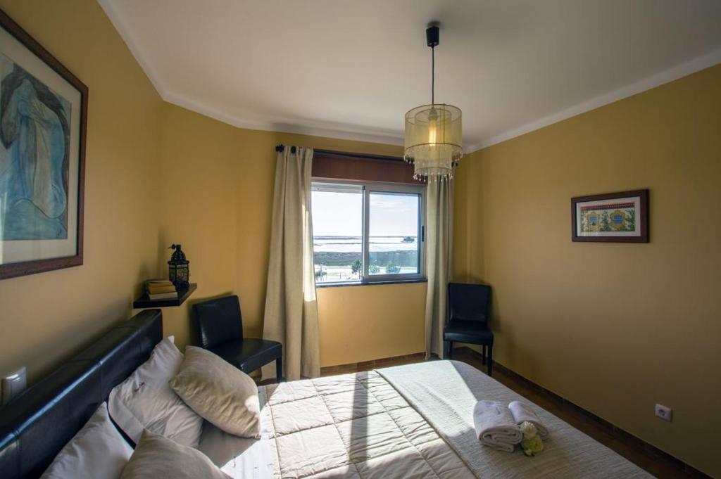 um quarto com uma cama e uma janela em Apartamento Ria Formosa na Fuzeta