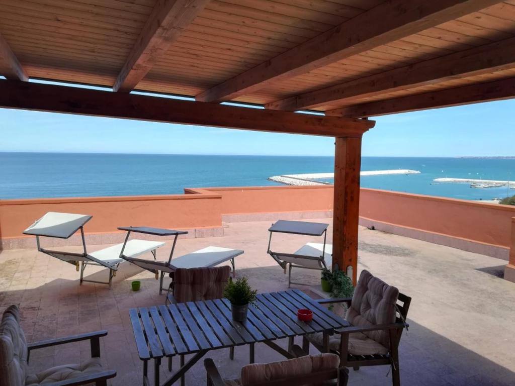 a patio with a table and chairs and the ocean at Attico Giusy in Balestrate