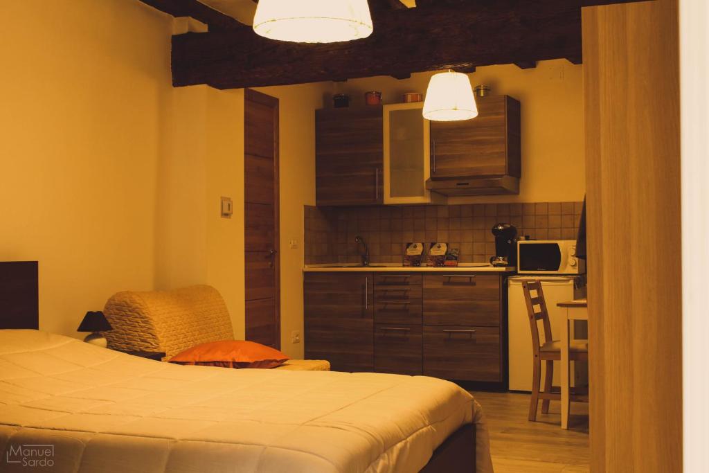 ein kleines Schlafzimmer mit einem Bett und einer Küche in der Unterkunft Casa Cisa in Muggia