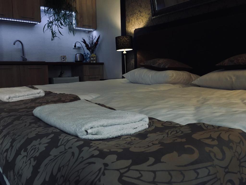 łóżko z dwoma ręcznikami na górze w obiekcie Apartament Ormiańska w mieście Zamość