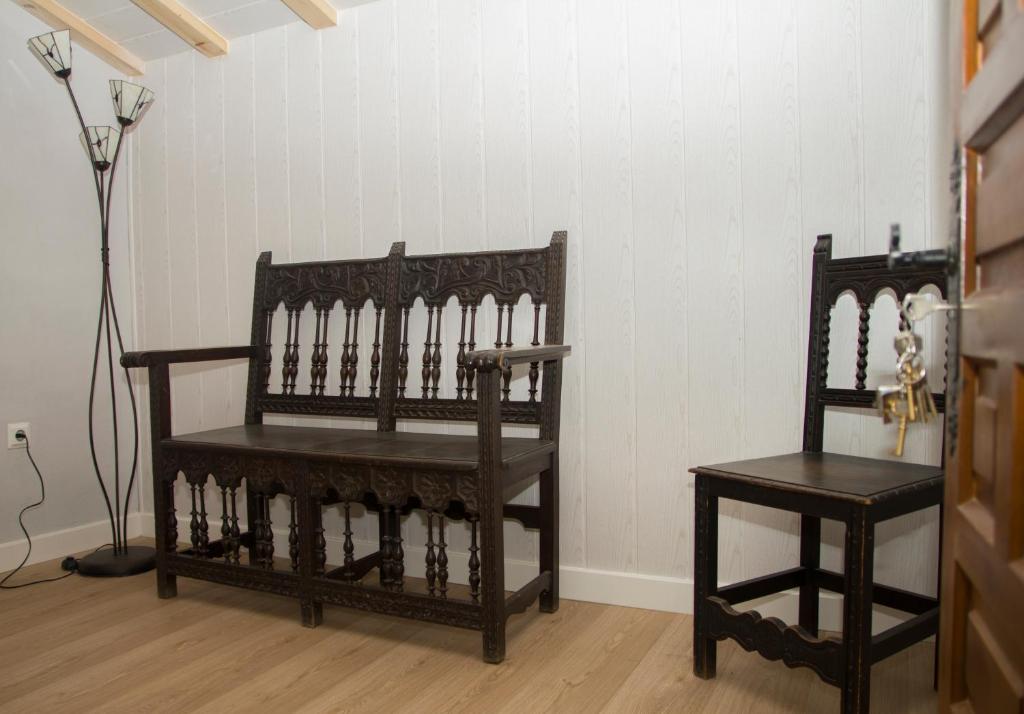 um quarto com duas cadeiras de madeira e um candeeiro em Casa Rural el Cedro em Abejar