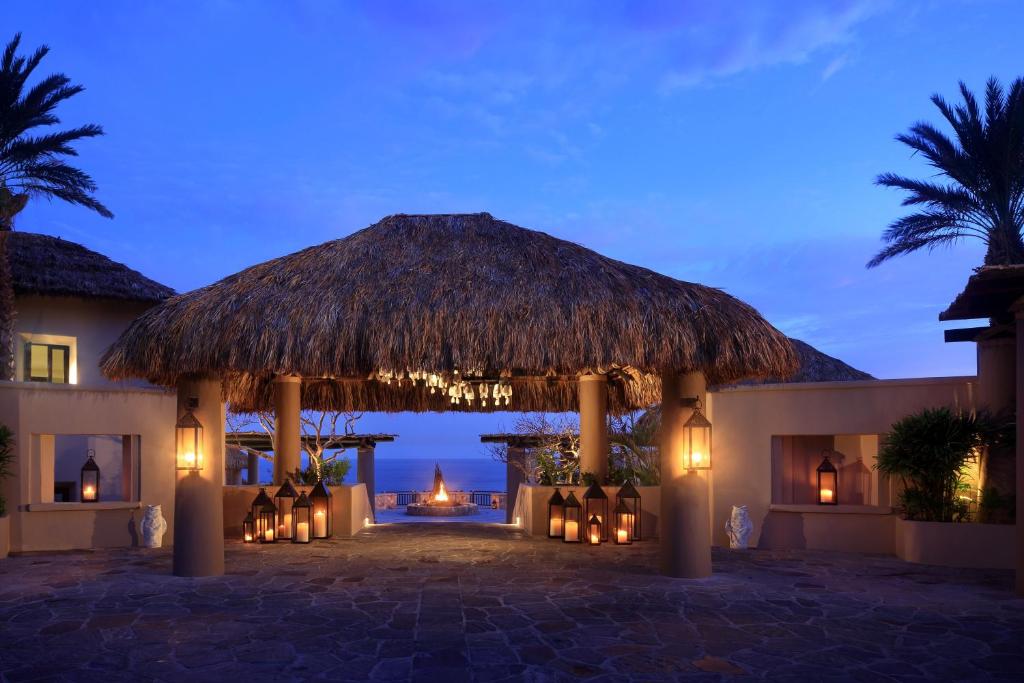 カボ・サン・ルーカスにあるEsperanza, Auberge Resorts Collectionの茅葺き屋根のパビリオン付きのリゾートで、海の景色を望めます。