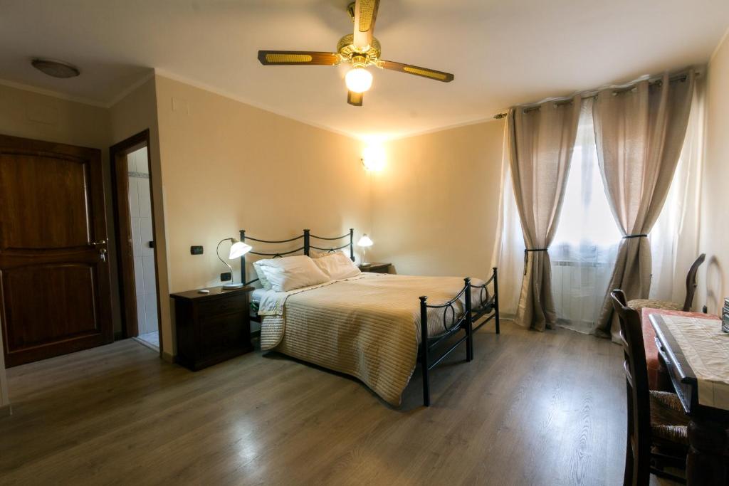 1 dormitorio con 1 cama y ventilador de techo en La Bella Casa del Cuoco, en Campi Bisenzio