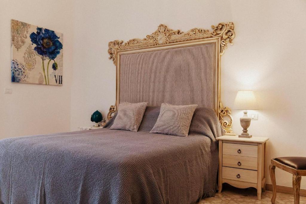 ファザーノにあるpalazzinApuliaのベッドルーム1室(大型ヘッドボード付きのベッド1台付)